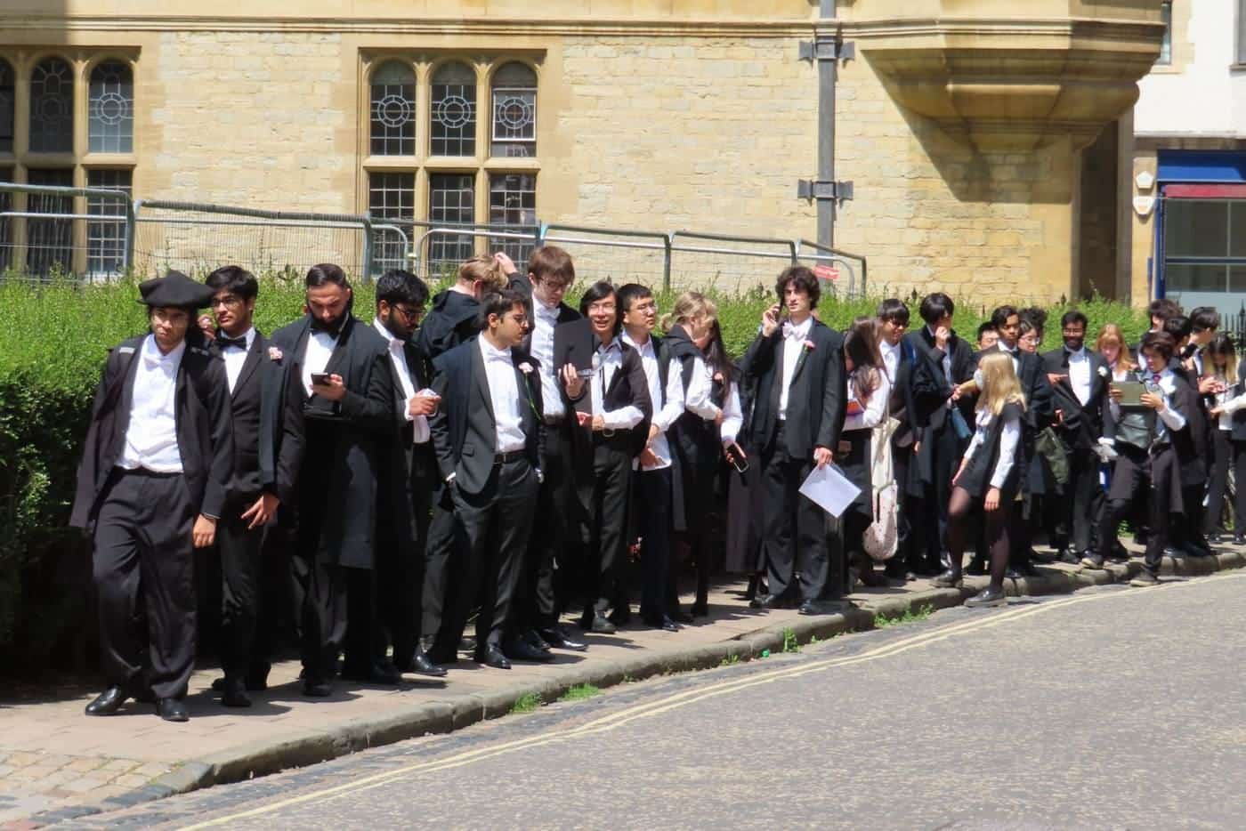 Students in formal dress lining up outside an exam venue
