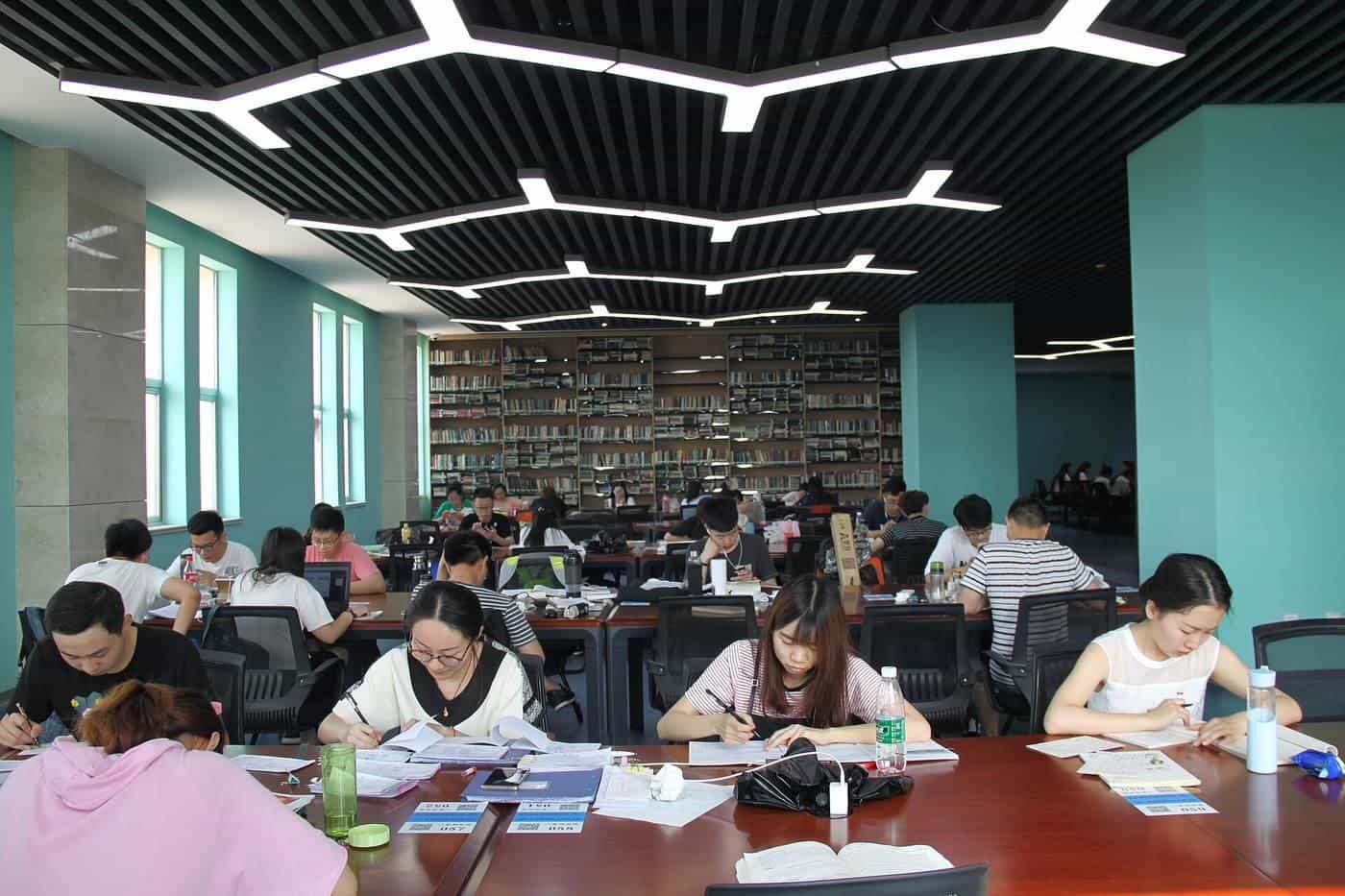 Students studying at desks in a large library