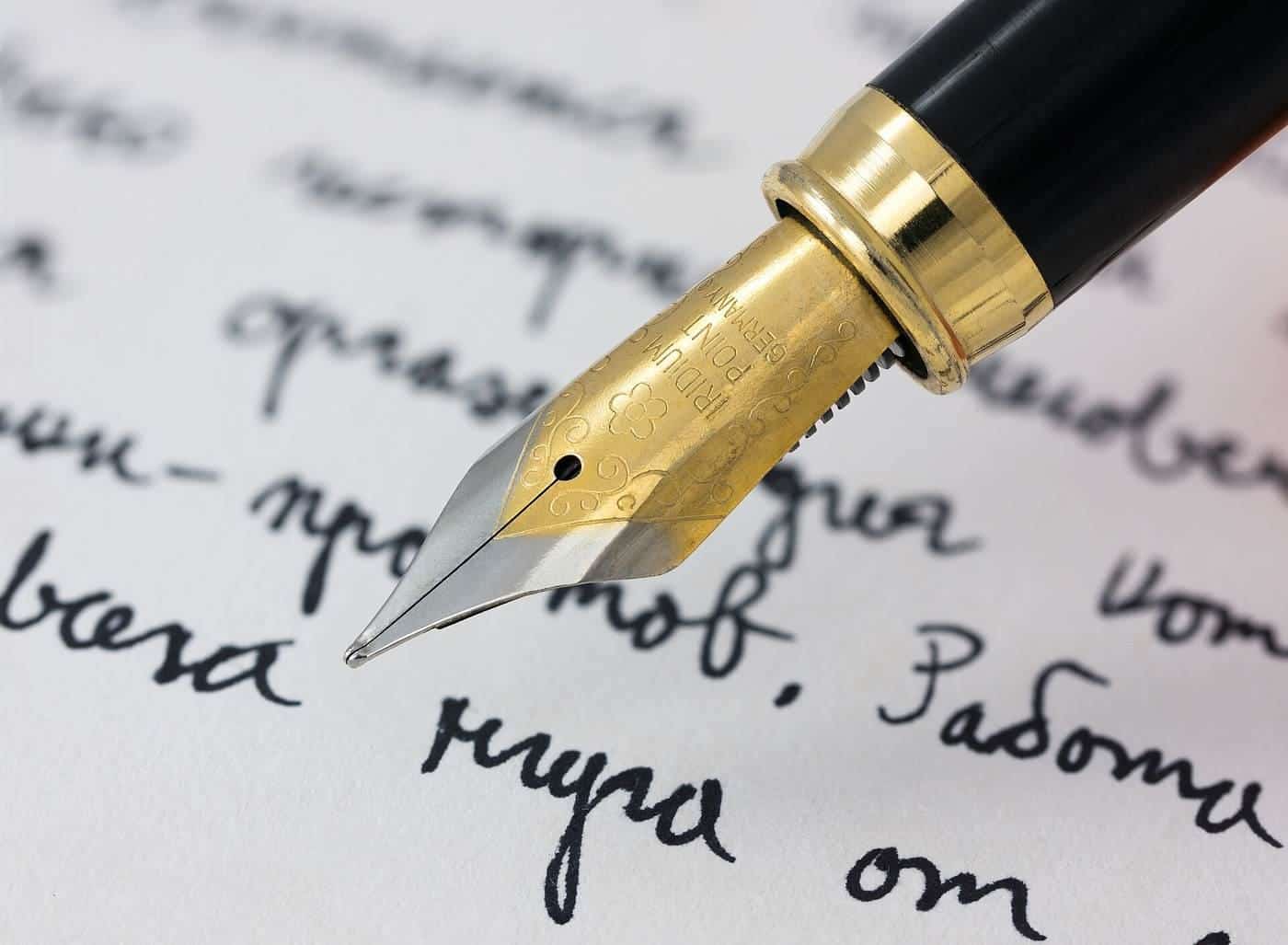 A fountain pen writing on lined paper