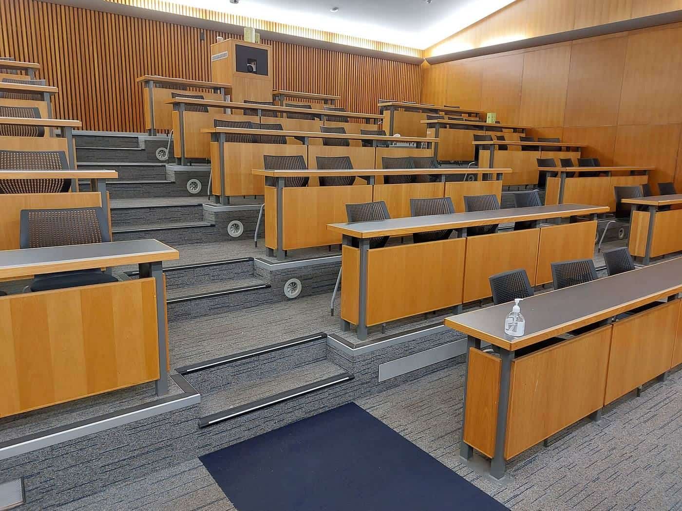 Tiered timber desks in an empty university lecture theatre