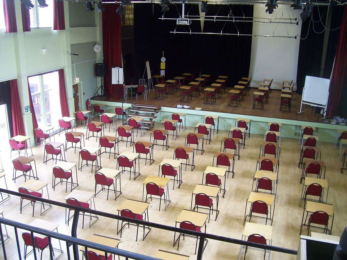 Rows of desks set out in an exam hall
